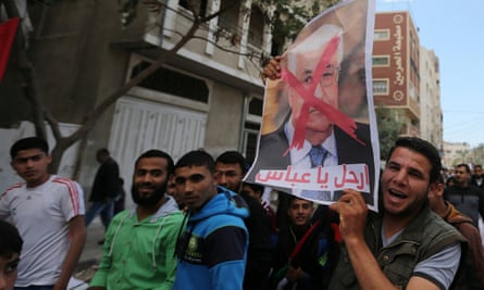 Hamas supporter holds a poster of President Abbas during a protest in southern Gaza.