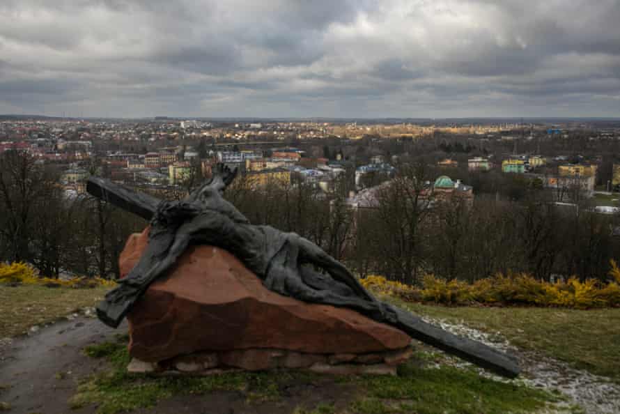 A sculpture of Jesus on the cross above a the city of Chełm