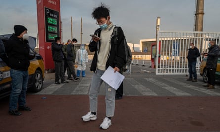 A man carries his release papers as he leaves after being released from a government quarantine facility on 7 December 2022 in Beijing, China.
