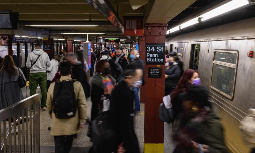 people walk through station as train is at platform