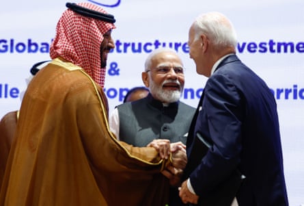 Narendra Modi, Joe Biden and Mohammed bin Salman clasp hands.