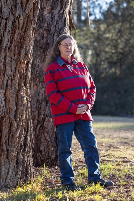 Sand Jeffs standing next to a tree trunk