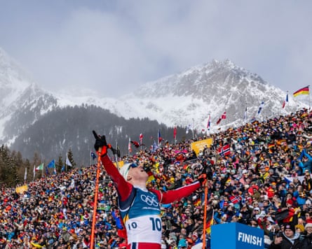 Johannes Dale-Skjevdal crosses the finish line to win a gold for Norway in the biathlon at the Winter Olympics.