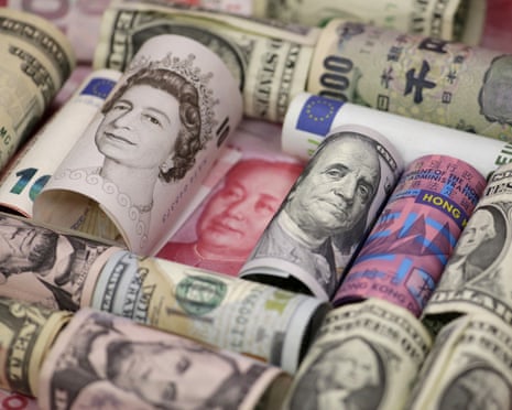 Rolled banknotes from various world currencies bundled together, showing portraits and colours