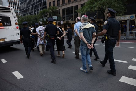 police lead detained people to a vehicle