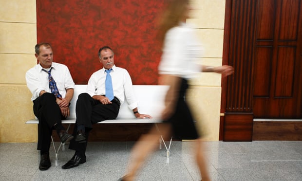 Two businessmen looking at a passing woman’s legs