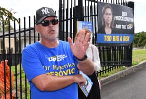 An LNP booth worker (left) is seen reacting towards Queensland Premier Annastacia Palaszczuk