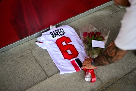 A Milan fan lays flowers next to a shirt of former captain Franco Baresi at Casa Milan