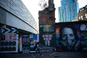 London, England A lone figure passes a Covid-19 mural on Brick Lane
