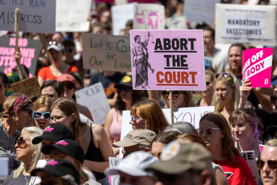 Demonstrators hold signs protesting abortion restrictions.  One sign reads 'Abort the court'.