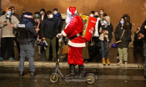 A man dressed as Santa Claus rides past a crowd in Rome