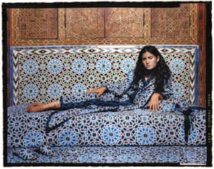 Supine woman is clothed in and surrounded by fabric that replicates the colourful zellij mosaic tile patterns