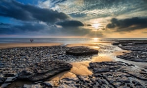 sunset over rocks and sand Dunraven Bay