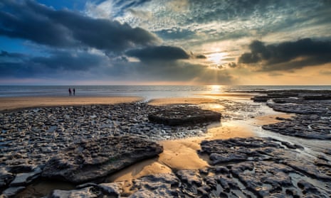 sunset over rocks and sand Dunraven Bay