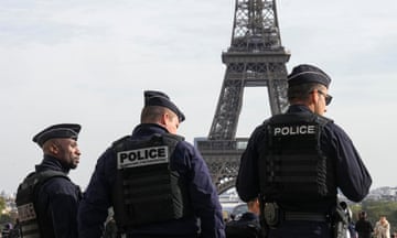 Police officers patrol the Trocadero plaza near the Eiffel Tower in Paris