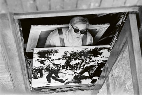 Warhol wearing a sandwich board featuring his prints of the race riots in Birmingham, Alabama, from the series Death and Disaster, which was his focus throughout 1963.