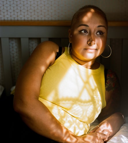 Sukhy Bahia, who is living with cancer, sitting on a bed, in yellow top