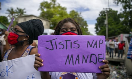 A protester holds up a sign that reads in Creole ‘We are asking for justice’, during Yves Jean-Bart’s meeting with the local district attorney last week.