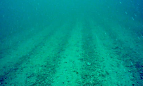 A video still showing deep furrows on a barren seabed