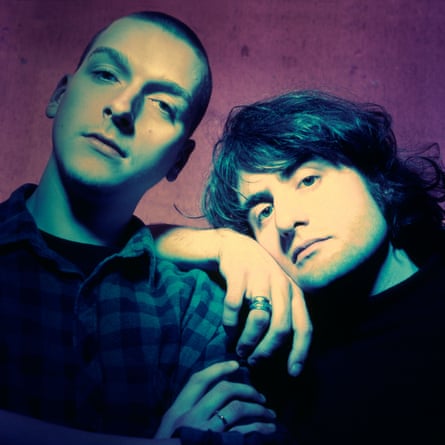 A colour-treated photo of Ben Green leaning on Justin Broadrick’s shoulder