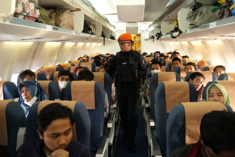 Indonesian citizens who are being evacuated from Sudan sit aboard a plane.