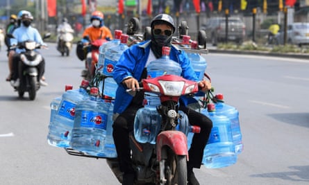 A man transports containers of water on his motorbike in Hanoi