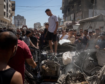 Palestinians look over the aftermath of an Israeli strike in Gaza.