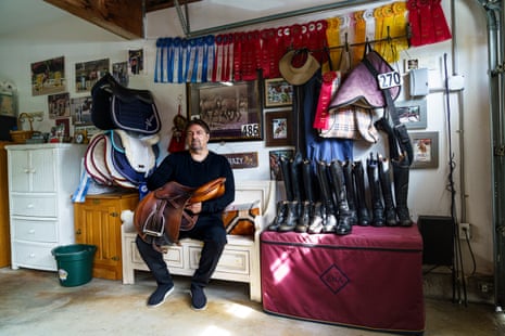 A man on a couch holding a saddle