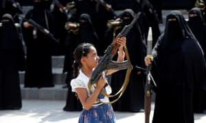 Girl holds a rifle in front of women loyal to the Houthi movement in Sana'a
