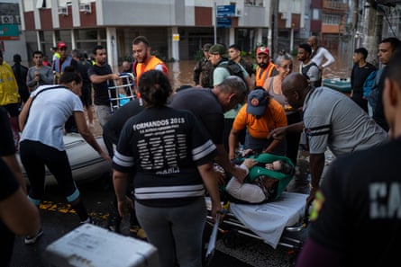 Rescuers and volunteers assist one of the flood victims in the Menino Deus neighbourhood in Porto Alegre.