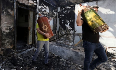 Torah scrolls, Jewish holy scriptures, are removed from a synagogue set on fire during violent confrontations in the city of Lod