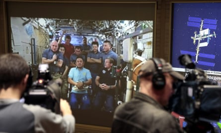 A screen of the Russian Mission Control Center shows live television of the International Space Station crew members as they take part in the news conference on Tuesday.