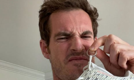 Andy Murray takes a whiff of his tennis shoes that were returned to him, with his treasured wedding ring attached to the shoelaces.