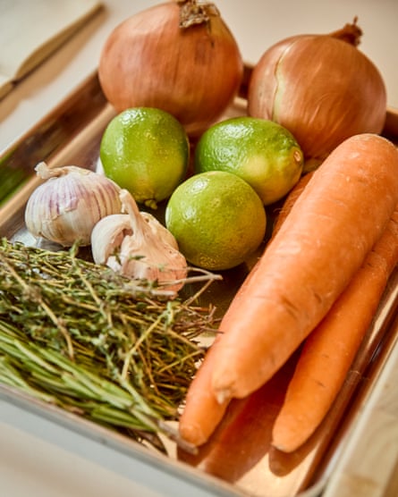 the veggie ingredients for venison chilli. There are carrots. onions, limes, garlic, and herbs.