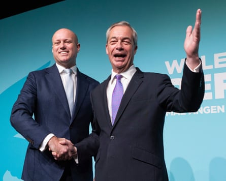 Dan Thomas shaking hands with Nigel Farage on stage