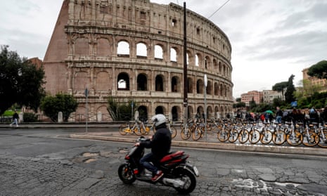 A motorcyclist rides over some of Rome’s 10,000 potholes on a road by the Colosseum.