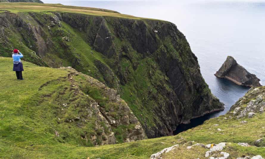 A birder on Fair Isle scans the cliffs.