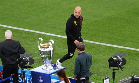 Pep Guardiola looks at the Champions League trophy in Istanbul