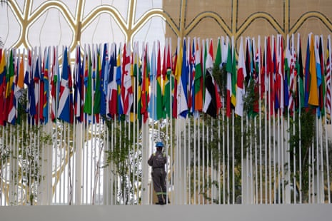 Finishing touches are made to the display of national flags outside the conference centre in Dubai.