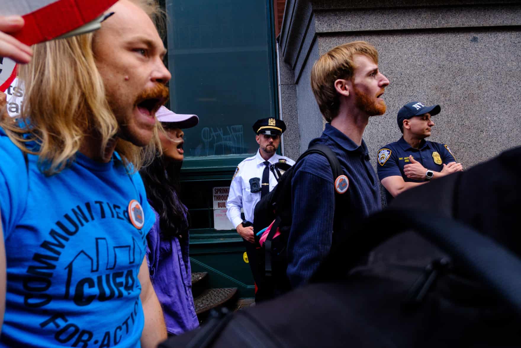 people chant while walking past police