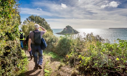 Walkers looking towards sunny offshore rock