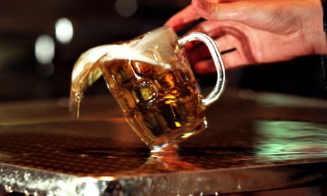 A pint of beer being spilled on a pewter bar