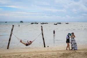 Tourists posing for photos with their mobile phones on a beach on Thailand’s Phi Phi Don island