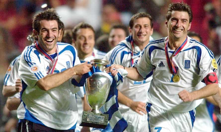 Georgios Karagounis, left, and Theodoros Zagorakis of Greece run with the Euro 2004 trophy