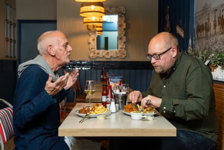Andrew and Jonathan chatting and eating at a restaurant table