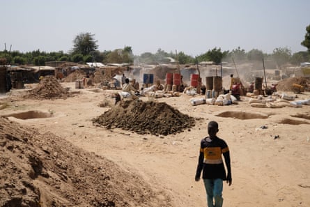 People, barrels and piles of earth