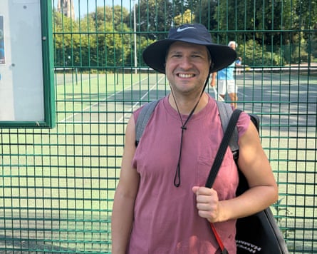 Marcos Ortega standing outside a public tennis court in a park