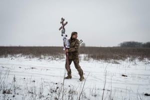 Oleksiy Storozh, 28, carries a cross to be placed at the grave of his late best friend in Sloviansk