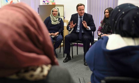 David Cameron speaks with women attending an English language class.