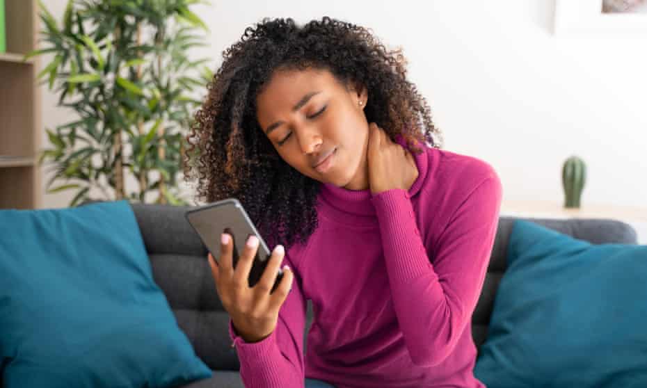 One black woman suffering having poor posture using mobile phonePosed by model Portrait of black woman feeling neck pain using cellphone